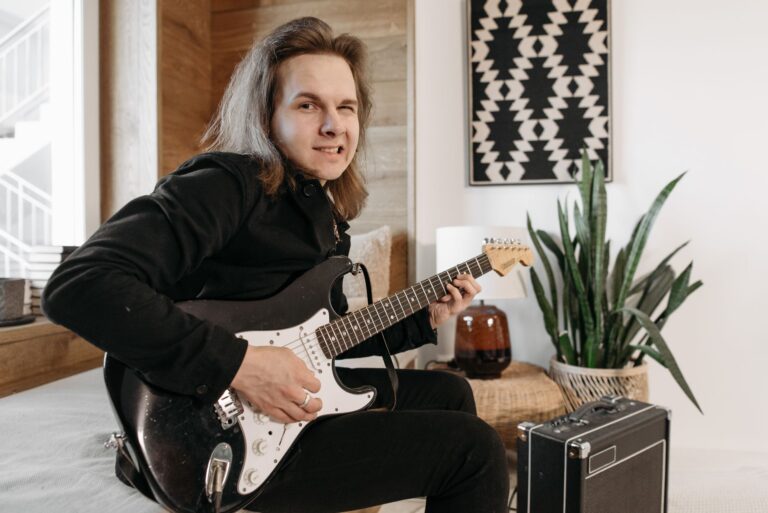 Anfänger übt E-Gitarre vor einem kleinen Verstärker