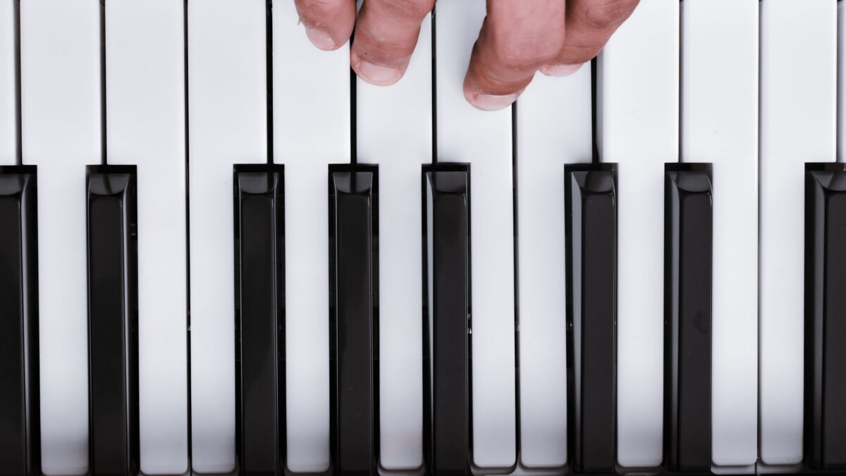 Hände spielen einen Akkord auf einer Klaviertastatur