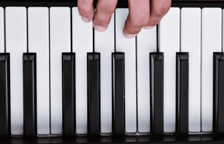 Hände spielen einen Akkord auf einer Klaviertastatur