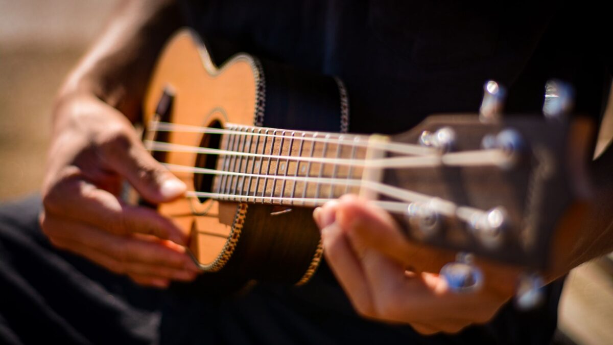 Hände greifen einen Akkord auf einer Ukulele